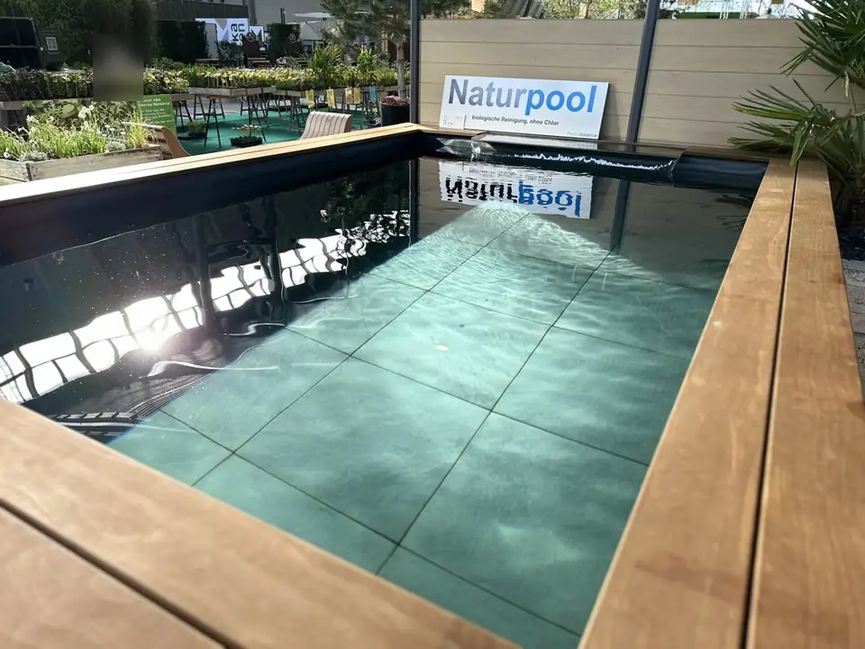 Naturpool mit Holzrand und Plattenboden auf dem Messestand